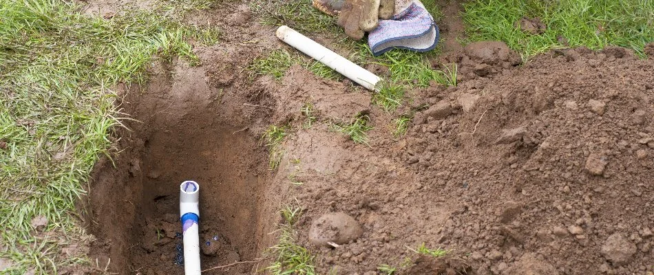 A white pipe in the ground for an irrigation system installation in Tarrytown, NY.