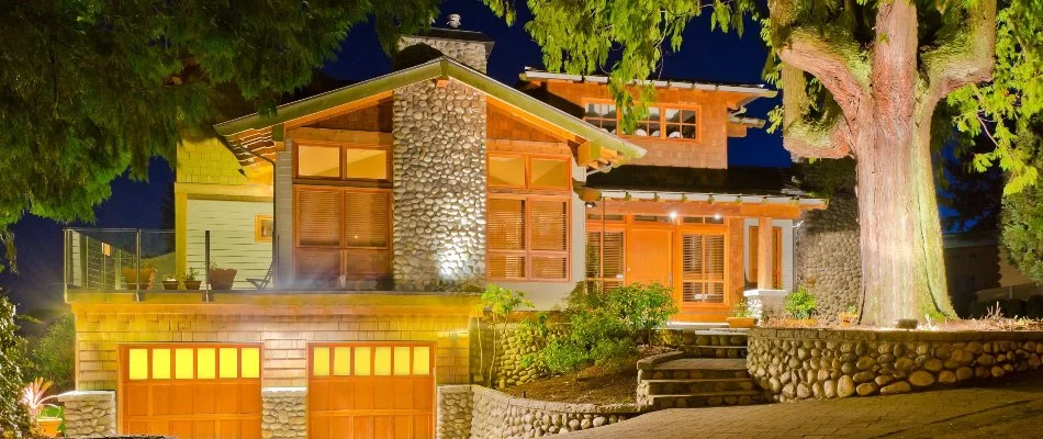 House and large tree in Middletown Township, NJ, with outdoor lighting.
