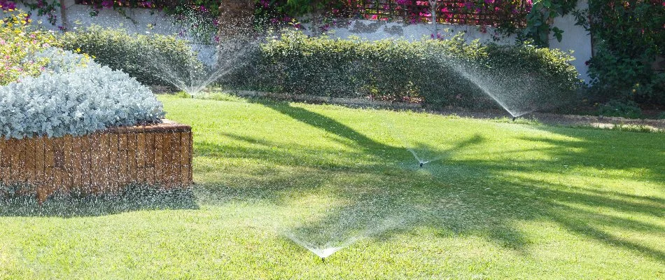 A property in Hackensack, NJ, with multiple sprinkler systems watering a lawn.