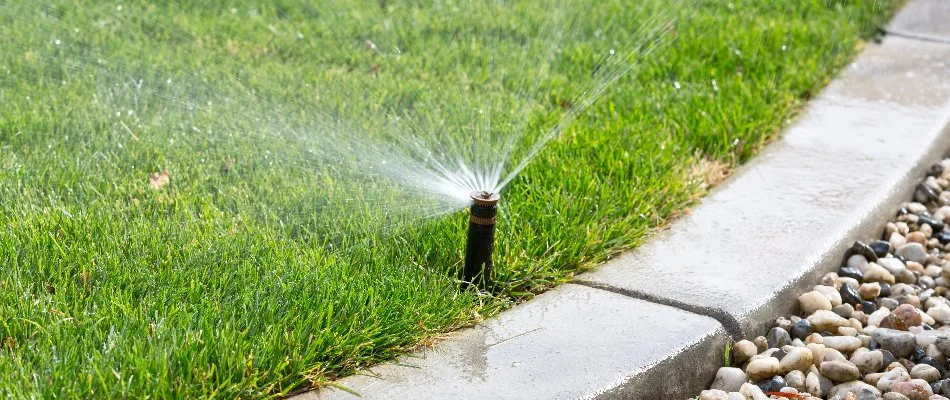 A sprinkler system spraying a lawn with water in Westchester County, NY.