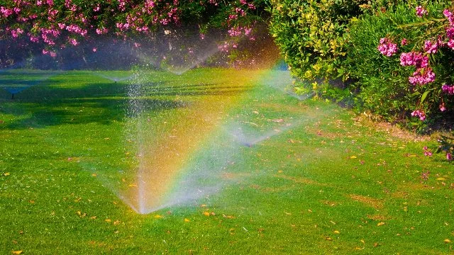 Sprinkler running causing rainbow at property in Alpine, NJ.